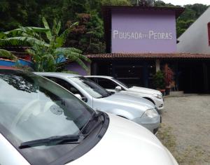 een rij geparkeerde auto's geparkeerd op een parkeerplaats bij Pousada das Pedras in Toque Toque Pequeno