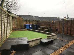 a backyard with a green lawn and a picnic table at 8 Queenora Avenue in Portstewart +2 photos