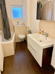 ein Badezimmer mit einem weißen Waschbecken und einem WC in der Unterkunft Zentrales WG-Zimmer 1 Ravensburg, Balkon, Kamin in Ravensburg