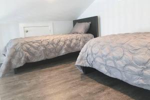 a bedroom with two beds and a wooden floor at Beach Front on West Beach in Galveston