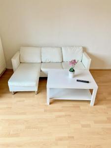 ein Wohnzimmer mit einem weißen Sofa und einem Couchtisch in der Unterkunft Zentrales WG-Zimmer 1 Ravensburg, Balkon, Kamin in Ravensburg