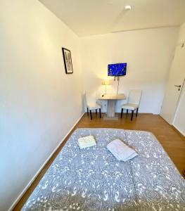 1 dormitorio con 1 cama y 1 mesa con sillas en Gemütliches WG-Zimmer 2, zentral in Ravensburg en Ravensburg