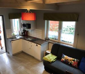 a living room with a couch and a kitchen at Domek pod lasem in Pogorzelica