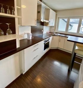 a kitchen with white cabinets and a wooden floor at Zentrales WG-Zimmer 3 in Ravensburg stadtnah in Ravensburg