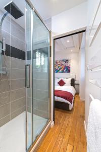a bathroom with a shower and a bed in a room at Hypercentre Calme et Cosy, Impasse Saint Julien, 2eme étage in Angers