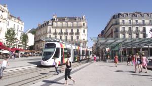 a city street with people walking and a tram at Hypercentre Calme et Cosy, Impasse Saint Julien, 2eme étage in Angers