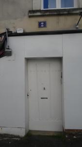une porte de garage blanche avec un panneau sur celle-ci dans l'établissement Hypercentre Calme et Cosy, Impasse Saint Julien, 2eme étage, à Angers
