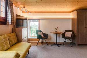 a living room with a couch and a table at Pension Staldacher in Hasliberg