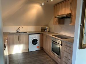 uma cozinha com uma máquina de lavar roupa e um lavatório em Ayr Loft Apartment with Fabulous Views em Ayr