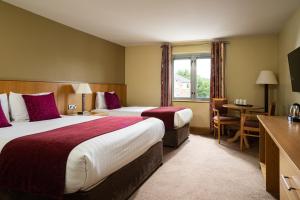 a hotel room with two beds and a desk at Belmore Court & Motel in Enniskillen