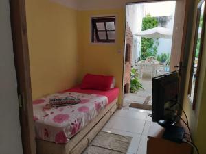 um quarto com uma cama, uma televisão e um pátio em Hostel Icaraí Inn em Niterói
