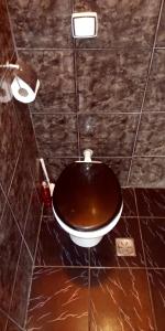a bathroom with a toilet in a tiled room at Hostel e Pousada Solar in Poços de Caldas