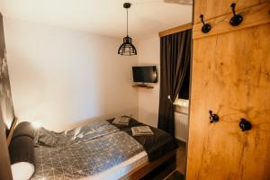 Un dormitorio pequeño con una cama y un televisor. en WOLF apartments, en Jahorina