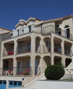 un edificio de apartamentos con balcones y sillas rojas en Fox Apartments, en Cavtat