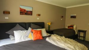 a bedroom with a bed with pillows on it at Diana Alpine Lodge in Falls Creek