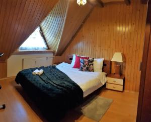 een slaapkamer met een bed met een zwarte deken en een raam bij Apartament High Hill in Zakopane