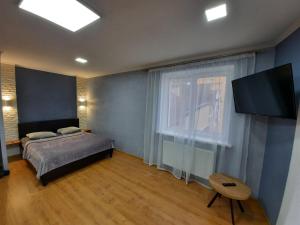 1 dormitorio con 1 cama y TV de pantalla plana en НОВІ квартири біля вокзалу ІФ "ХОЧУ ЦЮ", en Ivano-Frankivsk