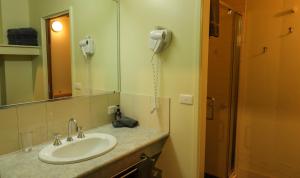 a bathroom with a sink and a phone on the wall at Diana Alpine Lodge in Falls Creek +17 photos