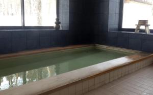 a bath tub filled with water in a bathroom at Double Black Hotel in Hakuba