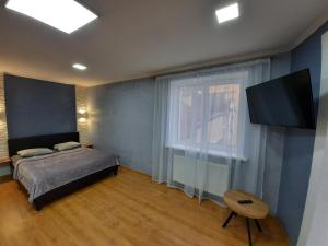 um quarto com uma cama e uma televisão de ecrã plano em НОВІ квартири біля вокзалу ІФ "ХОЧУ ЦЮ" em Ivano-Frankivsʼk
