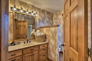 a bathroom with a sink and a mirror at Hot Tub, Grill Hilltop Log Cabin in Hot Springs! in Hot Springs +24 photos