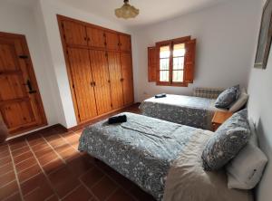 a bedroom with two beds and a door at Casa Rural Huerta Abuela María in Archidona +55 photos