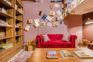 salon z czerwoną kanapą i książkami w obiekcie Selina Aurora Sao Paulo w São Paulo