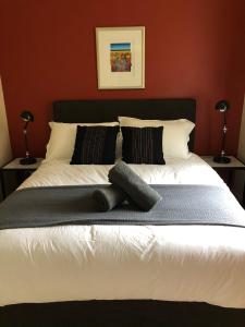 a bedroom with a large white bed with two pillows at Attunga Alpine Lodge & Apartments in Falls Creek