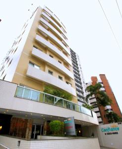 um edifício alto com plantas ao lado dele em Hotel Confiance Batel em Curitiba