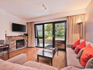 ein Wohnzimmer mit Couch und Kamin in der Unterkunft Lantern 10 Deluxe - Parking in Thredbo + 7 Fotos