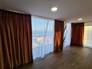 a room with a large window with curtains at Sea View Hills in Sveti Vlas