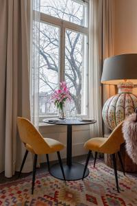 Zimmer mit einem Tisch, Stühlen und einem Fenster in der Unterkunft Bossche Suites Stationsweg in ’s-Hertogenbosch