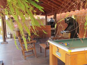 una mesa de billar en un patio con vides en Pousada Quinta Das Aroeiras, en Olímpia