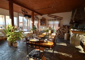 a room with a long table and chairs in a restaurant at Les chambres et Roulottes des Noisetiers in Leysin