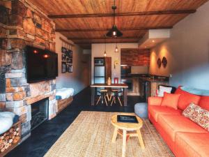 a living room with a couch and a fireplace at Lantern 1 Bedroom Balcony Alpine Style in Thredbo