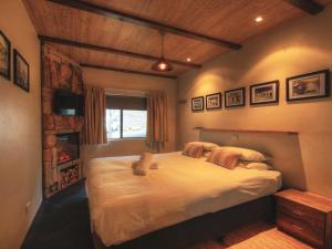 a bedroom with a large bed and a fireplace at Lantern 1 Bedroom Balcony Alpine Style in Thredbo