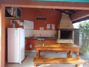 a kitchen with a refrigerator and a table and a stove at Apartamento em Boracéia no Litoral Norte in Bertioga