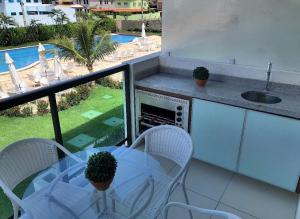 een balkon met een tafel en stoelen en een wastafel bij Laguna Beach Flat -205 in Porto De Galinhas