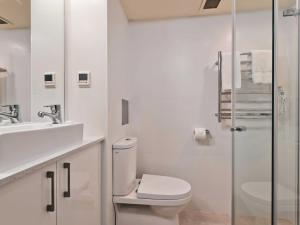 a white bathroom with a toilet and a sink at Lantern 24 Balcony in Thredbo