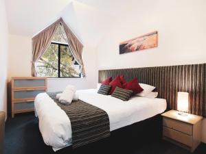 a bedroom with a large bed and a window at Lantern 1 Bedroom Loft with car space and Awesome View in Thredbo