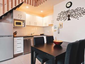 a kitchen with a table and a refrigerator and a counter at Lantern 1 Bedroom Loft with car space and Spectacular View in Thredbo