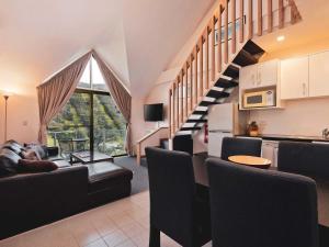 a living room with a couch and a stairway at Lantern 1 Bedroom Loft with car space and Spectacular View in Thredbo