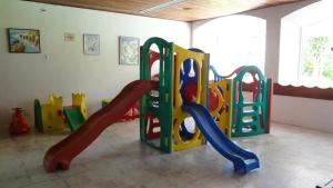 a childrens play room with a playground with a slide at Flat Cavalinho Branco - Apto 509 in Águas de Lindóia