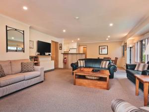 a living room with a couch and a table at Lhotsky 2 Bedroom apartment with balcony mountain views and BBQ in Thredbo