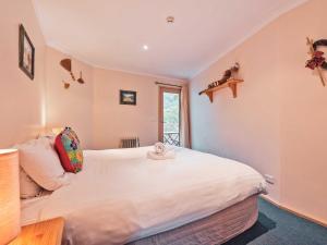 a bedroom with a large white bed and a window at Lhotsky 2 Bedroom with fireplace and sweeping mountain view in Thredbo
