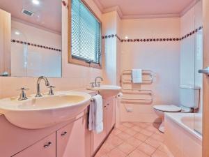 Baño blanco con lavabo y aseo en Lhotsky 2 Bedroom with fireplace and sweeping mountain view, en Thredbo