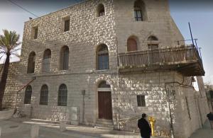 um homem parado em frente a um edifício de pedra em Mamilla Design Apartments em Jerusalém