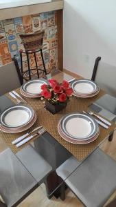 a table with plates and flowers on top of it at Apartamento mobiliado no centro de paulo afonso in Paulo Afonso