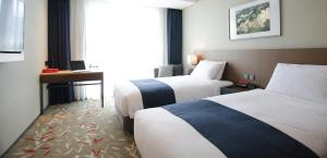 Postel nebo postele na pokoji v ubytování ASTI Hotel Busan Station