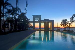 a swimming pool in front of a building with palm trees at Apartamento Le Club Acapulco in Acapulco +18 photos